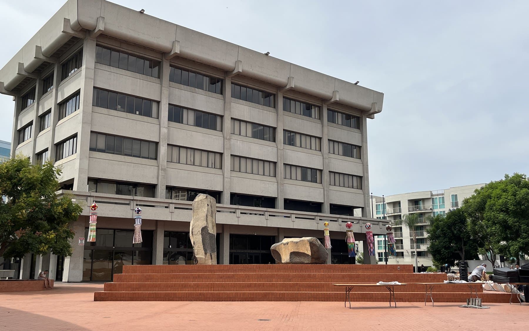 The concrete Japanese American Cultural and Community Center behind a brick plaza and stone sculpture