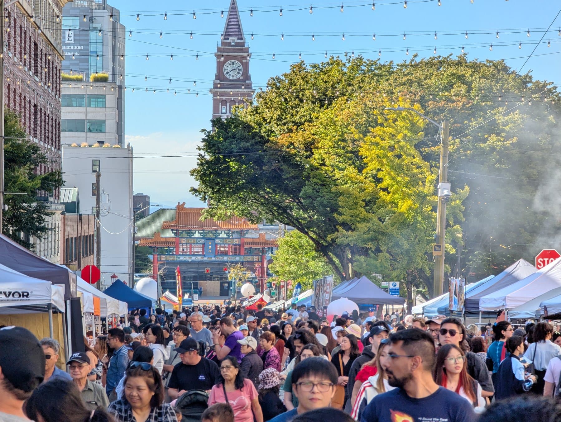 A crowded King Street looking west toward the Chinatown Gate and King Street Station clock tower during Seattle’s International District Night Market